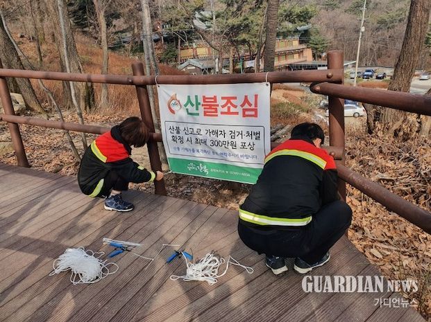 강북구 산불전문예방진화대가 북한산에 산불예방 현수막을 부착하고 있다.